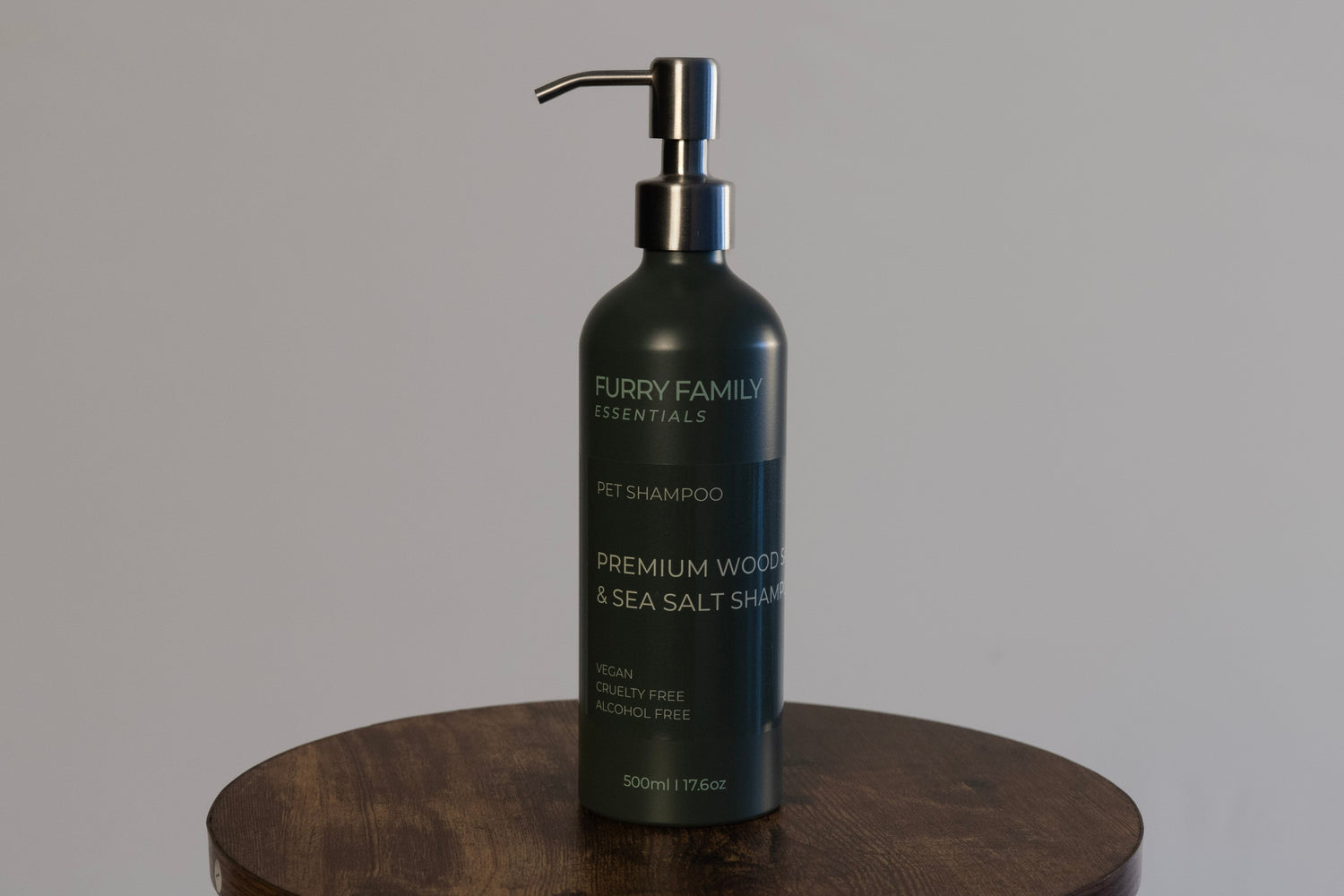 Furry Family Essentials pet shampoo bottle on a wooden surface with a gray background